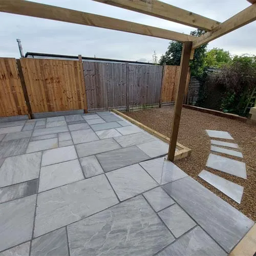 a stone patio with a wooden pergolan