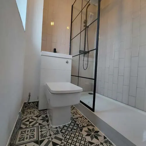 a white toilet sitting in a bathroom next to a walk in shower