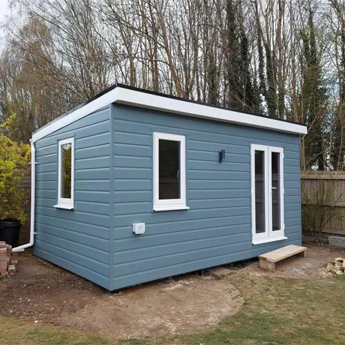 a small blue shed with a white window