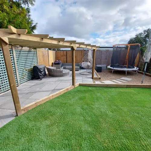 a backyard with grass and a wooden pergolan