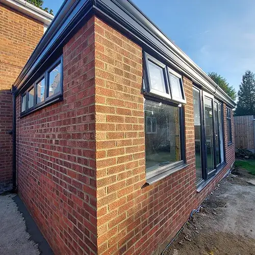 A brick building with a small window on the side of it. 