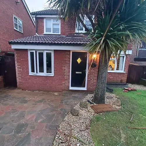 A brick house with a palm tree in front of it.