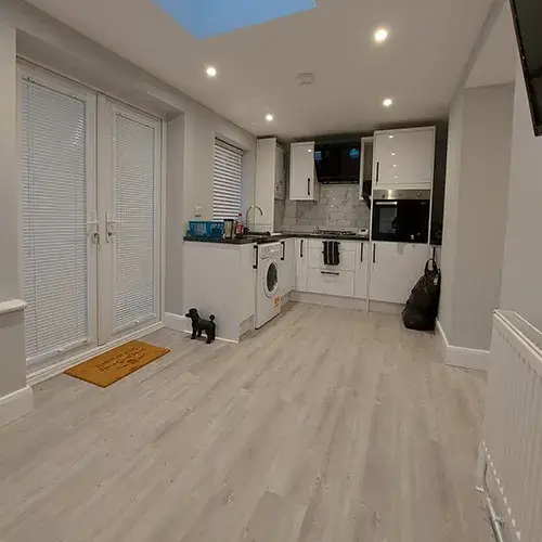 A kitchen with white cabinets and a skylight.