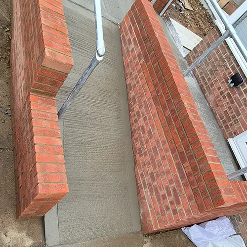 A red fire hydrant sitting next to a red brick building.