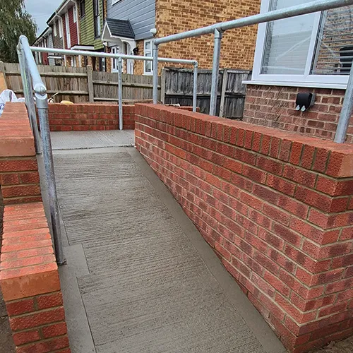 A red fire hydrant sitting on the side of a brick wall.