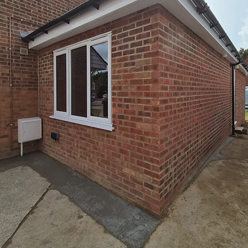 A red brick house with a white window.